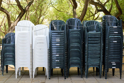 Stack of chairs against trees