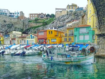 Boats moored at harbor against sky