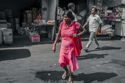 Rear view of people walking on road in city