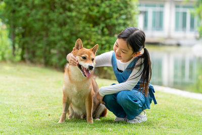 Girl with dog sitting on plant