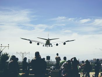 People on airplane against sky