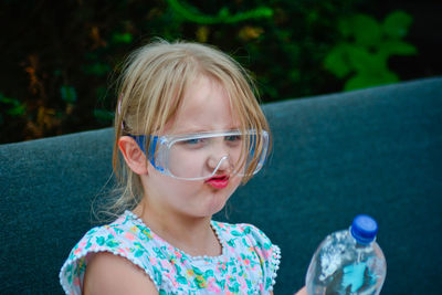 Cute girl making face while wearing protective eyewear