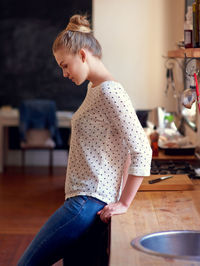 Side view of woman standing at home