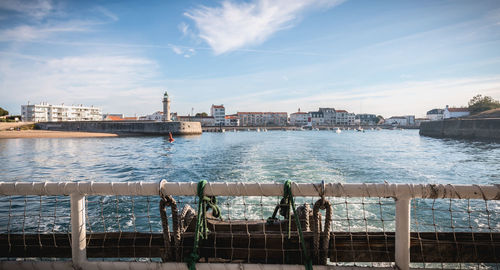 Scenic view of river by city against sky