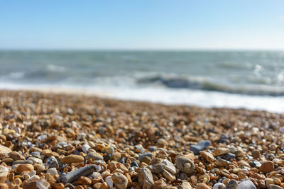 Close-up of pebbles on beach against clear sky