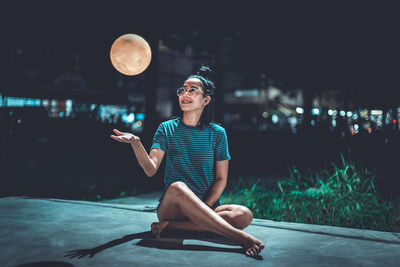 Full length of woman sitting outdoors