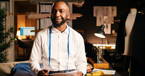 Portrait of young man standing in office