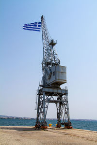 Ferris wheel by sea against clear sky