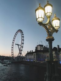 Illuminated street lights in city at dusk