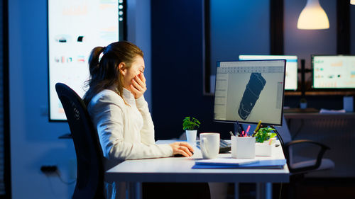 Woman using mobile phone at table