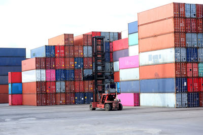 Stack of commercial dock by building against sky