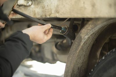 Cropped hand of mechanic repairing car