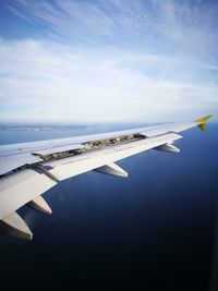 Airplane flying over sea against sky