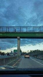 Suspension bridge against cloudy sky