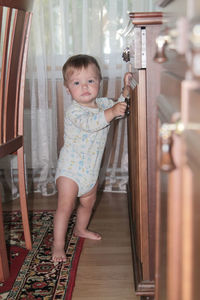 Portrait of cute baby girl standing at home