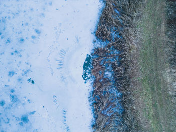 Aerial view of a frozen lake. ice sheet background. frozen grass on the lake. ice background.