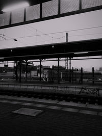 Train at railroad station in city against sky