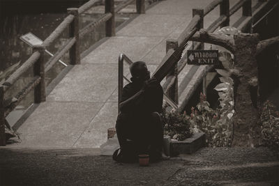 Rear view of woman sitting on staircase