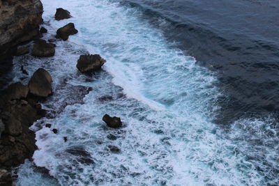 High angle view of rocks in sea taken from uluwatu temple