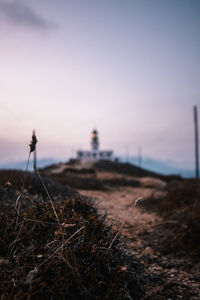 Surface level of land against clear sky view of lighthouse 