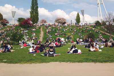 People relaxing on grassy field
