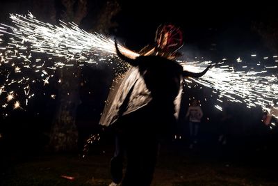 Silhouette woman with fire crackers at night