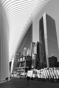 People in modern building against clear sky