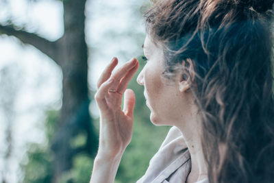 Close-up of woman looking away by tree