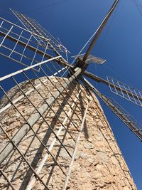 Low angle view of traditional windmill against clear blue sky