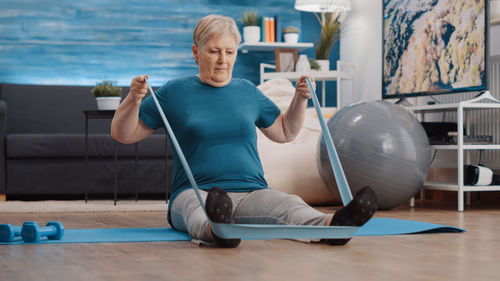 Full length of senior woman exercising at home
