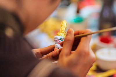 Cropped image of sculptor painting souvenir