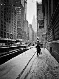 Man walking in city against sky