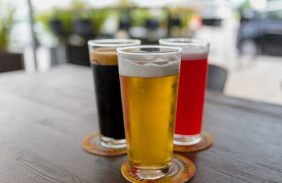 Close-up of three glasses of different craft beer in table in pub