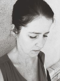 Close-up portrait of woman looking away against wall