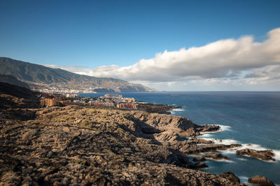 Scenic view of sea and mountains against sky