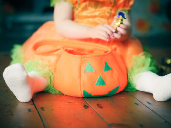 Low section of baby girl with chocolate sitting on floor