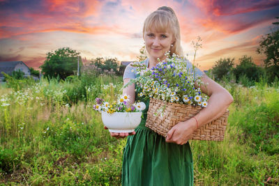 Portrait of young woman standing on field