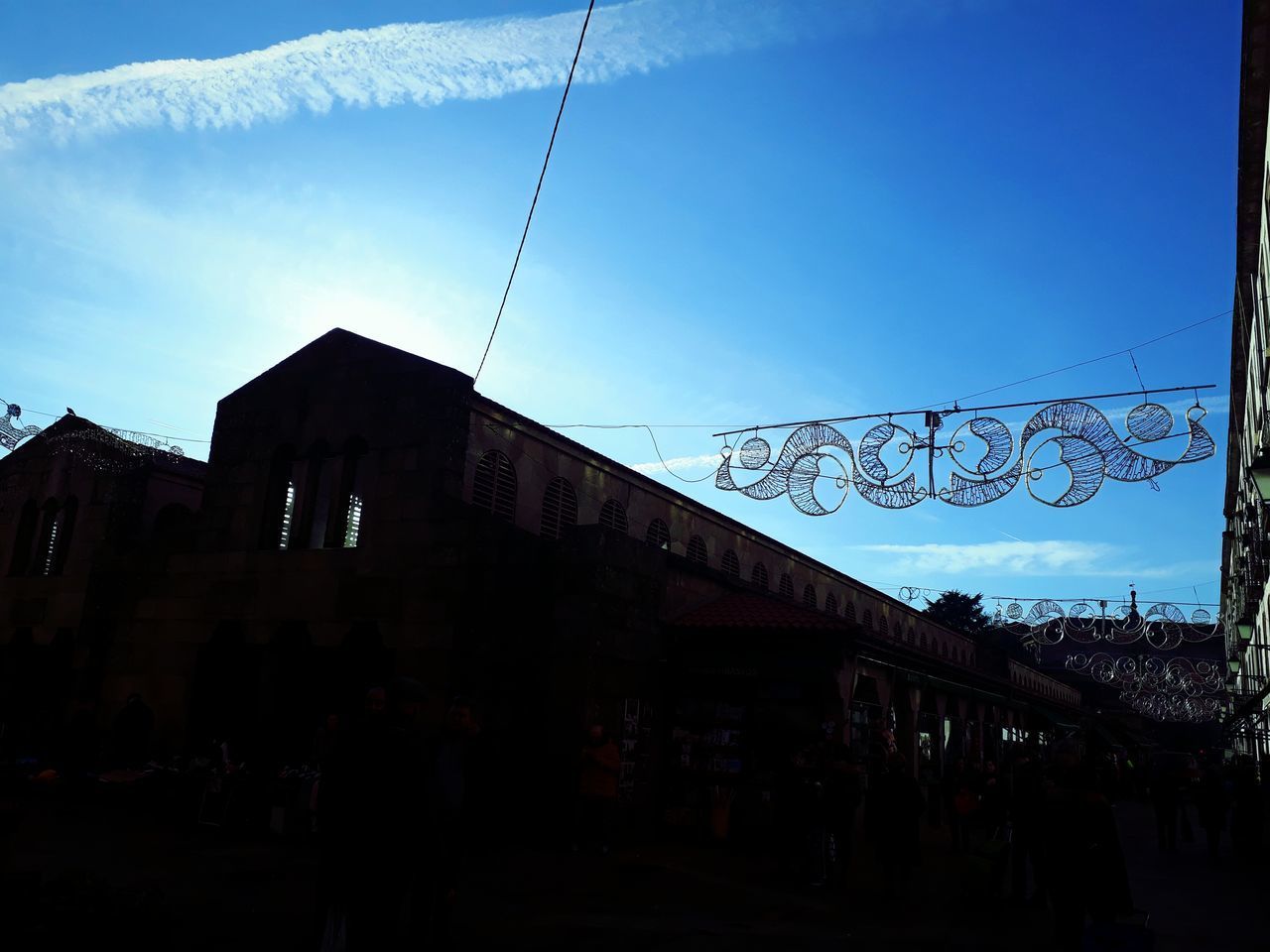 SILHOUETTE PEOPLE ON STREET AGAINST BUILDINGS