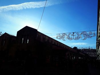 Silhouette people on street against buildings in city