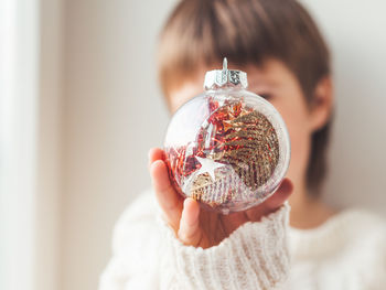 Kid with decorative ball for christmas tree.boy in cable-knit oversized sweater. snuggle weather.