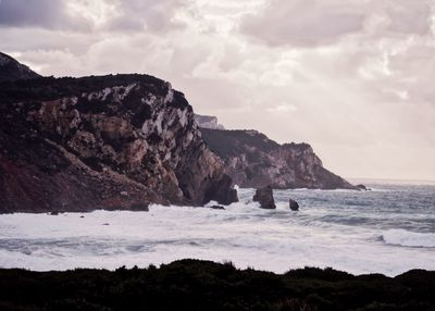 Scenic view of sea and rocky mountains