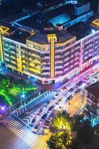 High angle view of illuminated city street and buildings at night