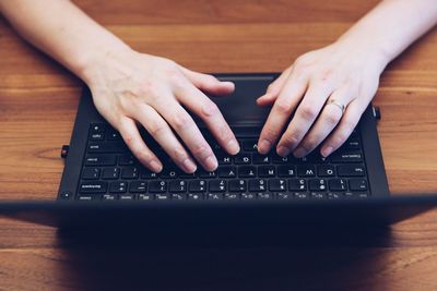 Midsection of man using laptop on table