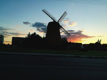 Silhouette of traditional windmill against sky during sunset