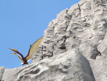 Low angle view of rocks against blue sky