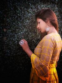 Side view of young woman standing outdoors