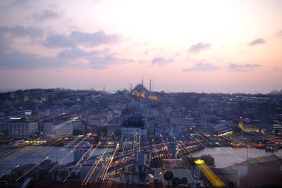 High angle view of city lit up at sunset