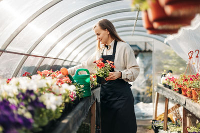 Woman standing by railing of flower