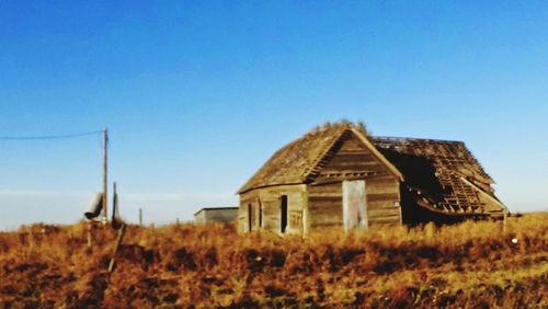 Built structure on landscape against clear blue sky