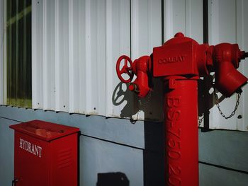 Close-up of red fire hydrant against wall